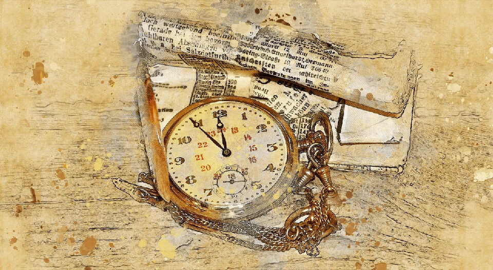 old fashioned pocket watch on top of folded newspaper page