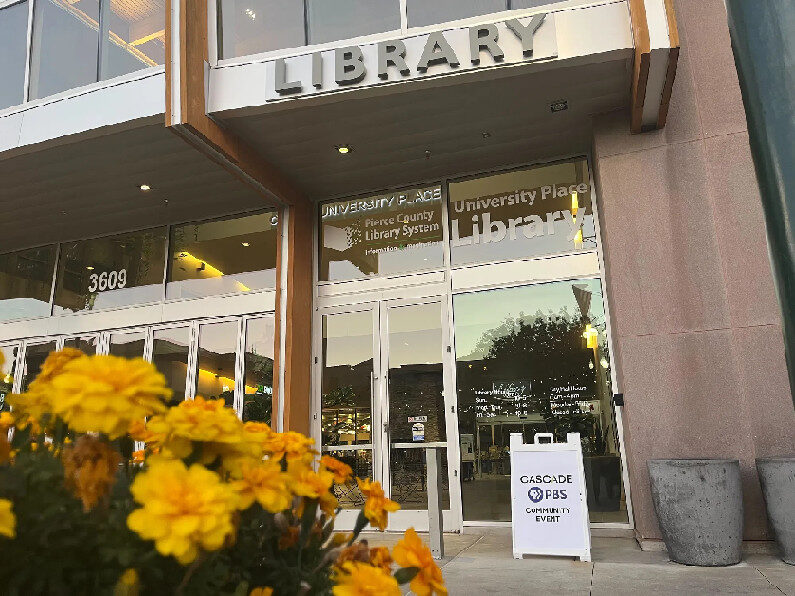 Photo of a library with a placard advertising a presentation by Cascade PBS