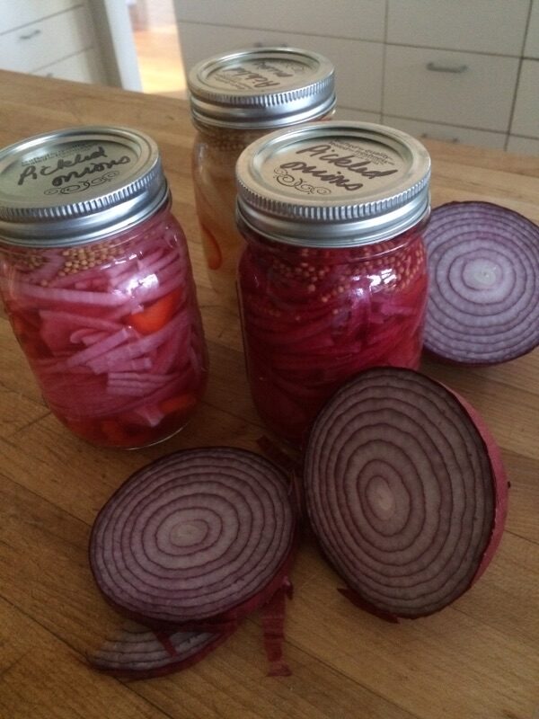 Red onions inside and outside of jars.